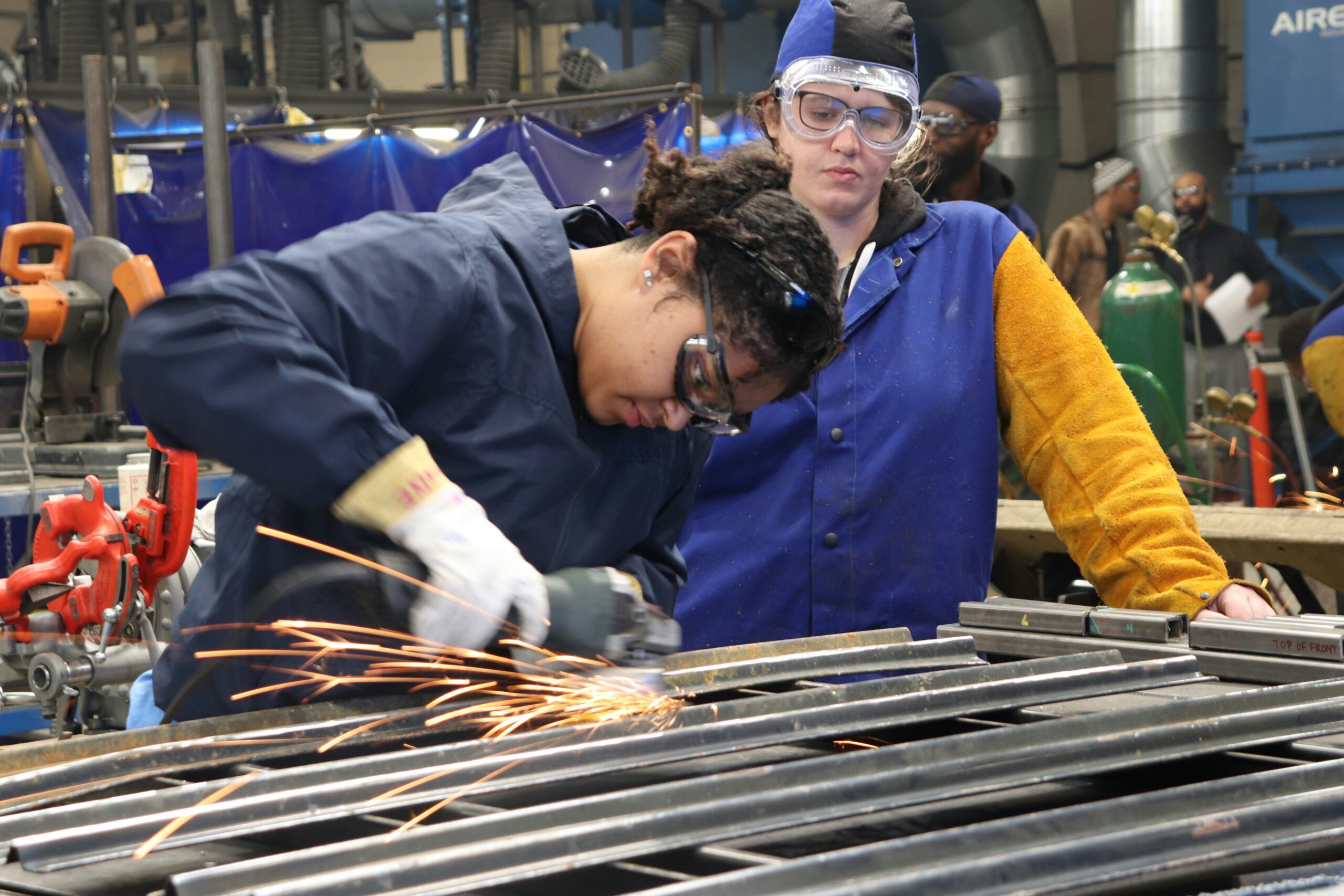 Two women are welding on the job or at a trade school.